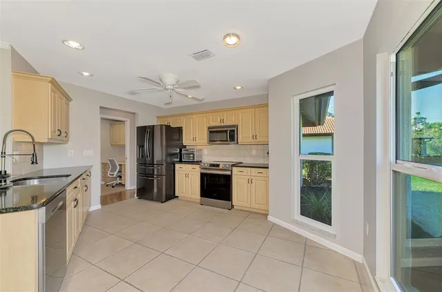 a living room with furniture and a large window with garden view
