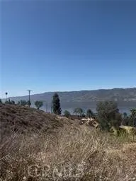 a view of a dry yard with wooden fence