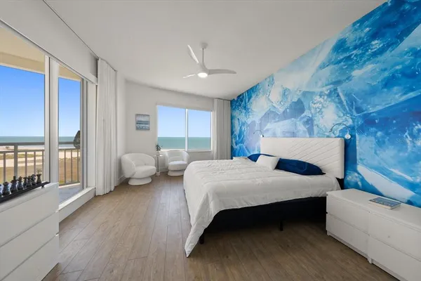 a bedroom with a bed couch and a large window