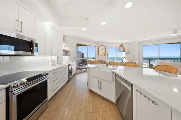 a kitchen with granite countertop a sink cabinets and stainless steel appliances