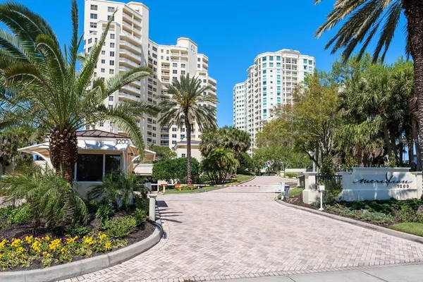 a front view of multi story residential apartment building with yard and outdoor seating