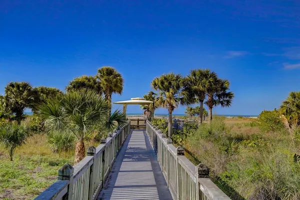 a view of a house with wooden stairs and a bench