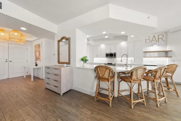 a kitchen with stainless steel appliances kitchen island granite countertop a table chairs sink and cabinets