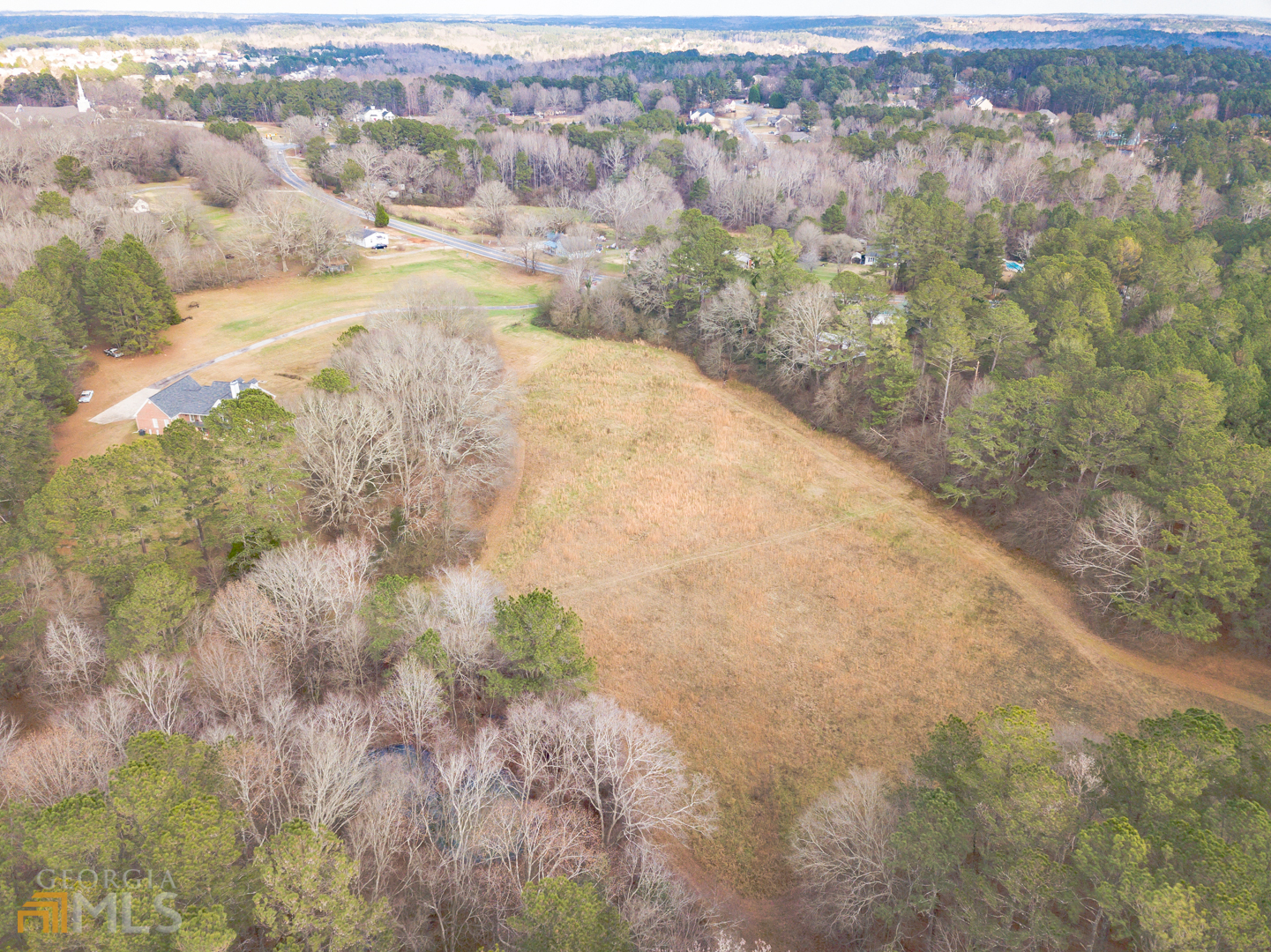 928 Grayson New Hope Road Lawrenceville, GA 30045 - Photo 7 of 36 a view of a dry yard with trees and houses