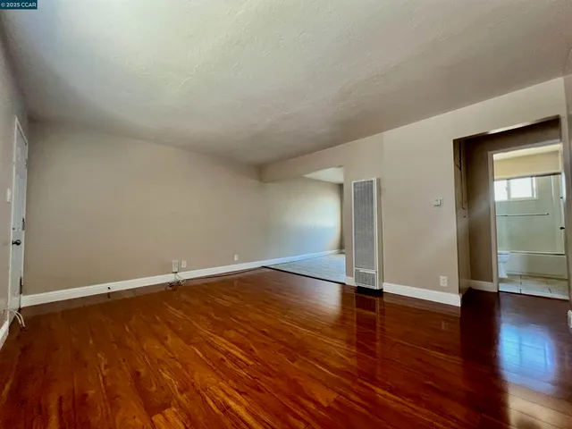 an empty room with wooden floor and closet