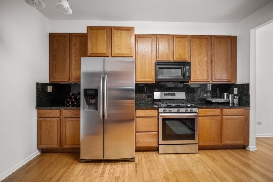 4643 Jenna Road Glenview, IL 60025 - Photo 5 of 17 a kitchen with granite countertop wooden floors stainless steel appliances and a counter space