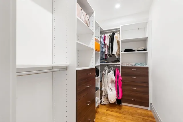 a view of walk in closet with clothes