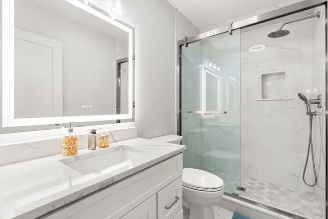 a bathroom with a sink a toilet and shower