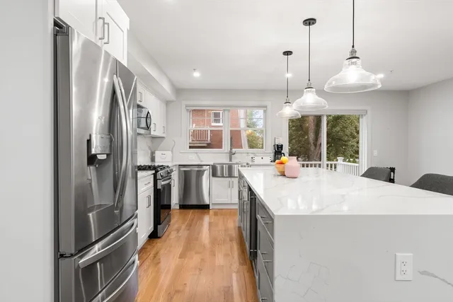 a kitchen with stainless steel appliances a stove refrigerator and cabinets
