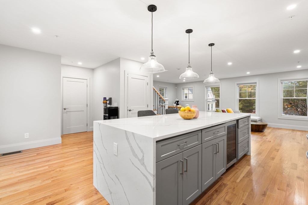 114 Broad Street, Unit D Weymouth, MA 02188 - Photo 5 of 41 a kitchen with stainless steel appliances kitchen island granite countertop a sink a stove and a wooden floor