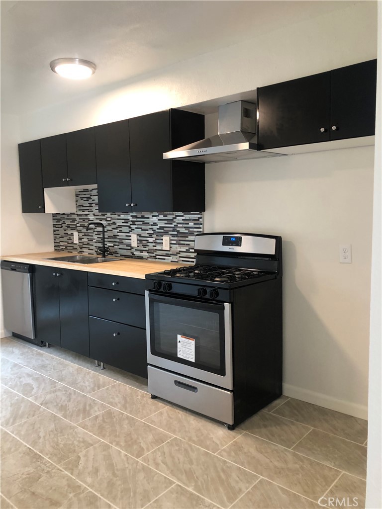 a kitchen with stainless steel appliances a stove and a microwave