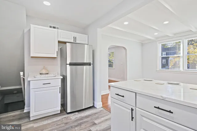 a kitchen with white cabinets and white appliances