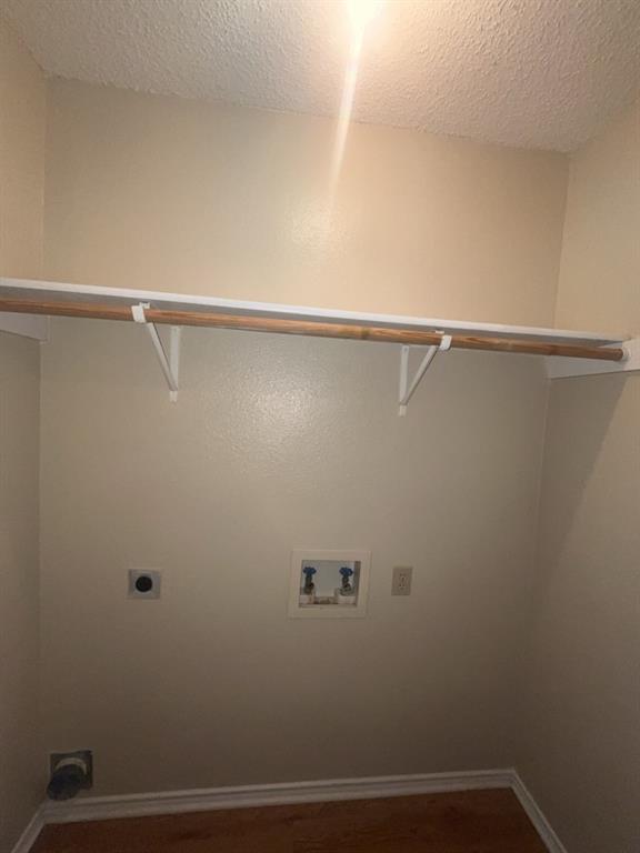 125 Northeast Johnson Avenue, Unit 30 Burleson, TX 76028 - Photo 9 of 13 Clothes washing area featuring washer hookup, a textured ceiling, electric dryer hookup, laundry area, and baseboards