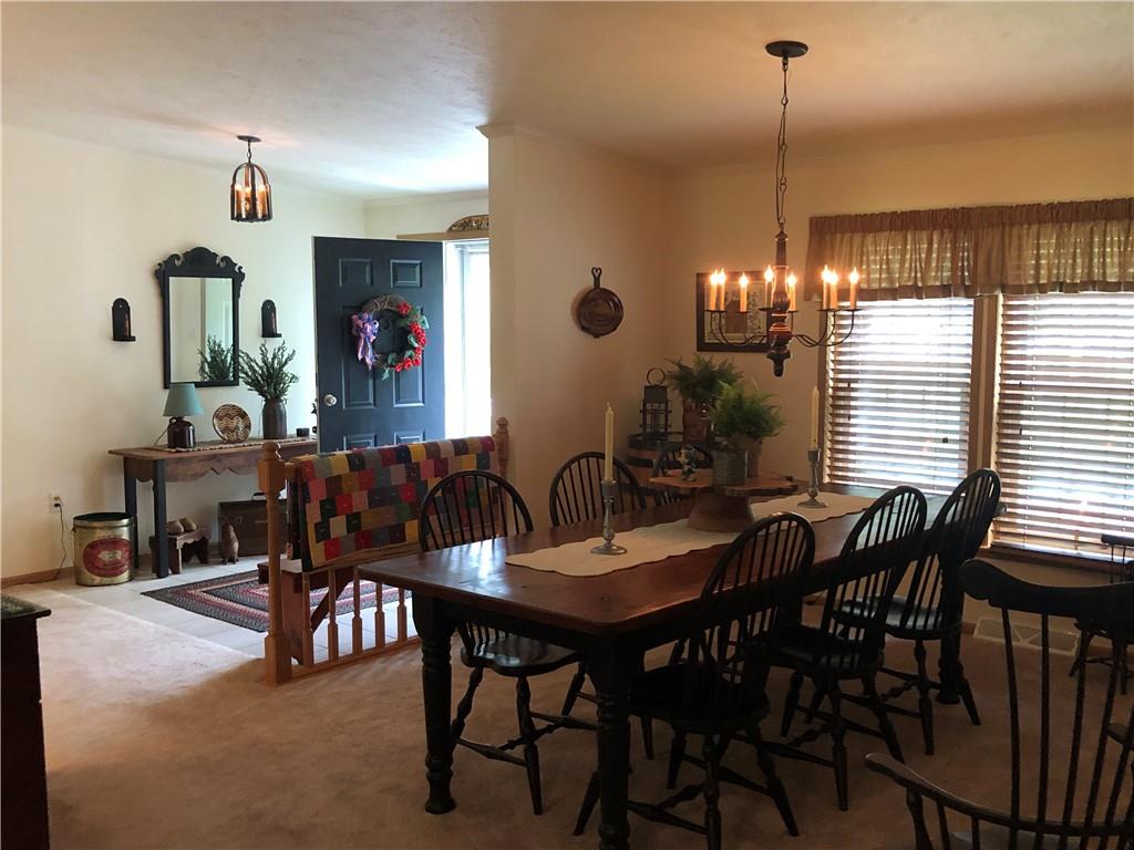 661 Nelson Road Farmington, PA 15437 - Photo 16 of 50 a view of a dining room and livingroom with furniture wooden floor a rug a painting and a chandelier