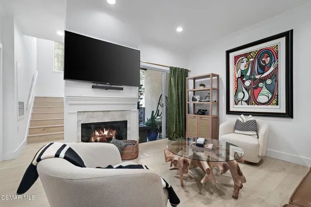 a living room with furniture a flat screen tv and a fireplace