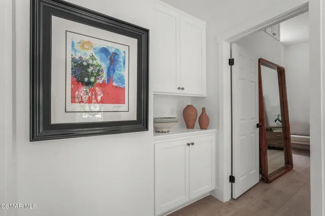 a room with a painting on the wall and a potted plant