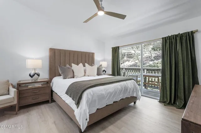 a bedroom with a bed lamp and a large window