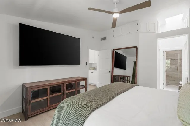 a bedroom with a bed and a flat screen tv