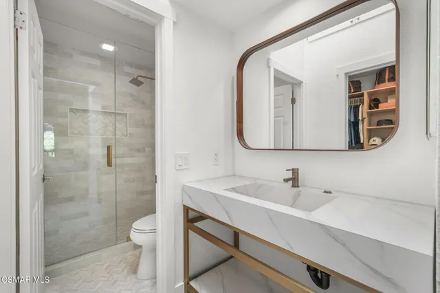 a bathroom with a sink a toilet and shower
