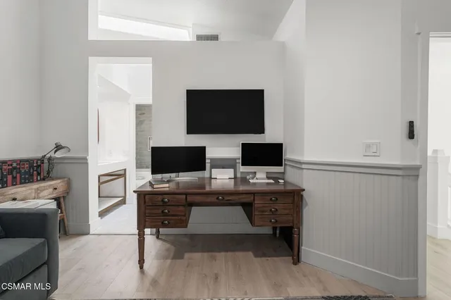 a view of a workspace with furniture and a flat screen tv