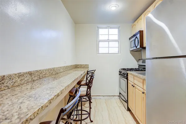 a view of a kitchen with wooden floor and electronic appliances