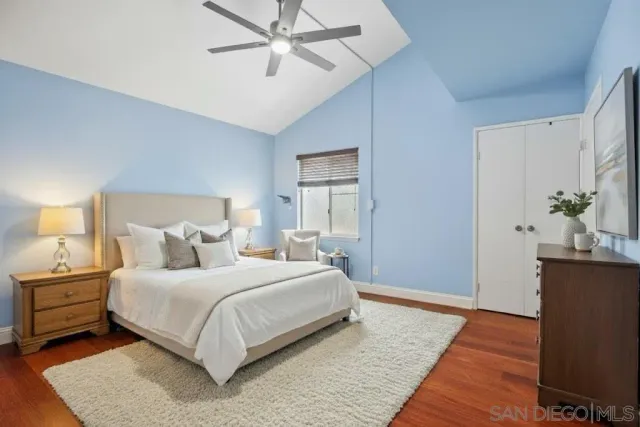 a bedroom with a bed lamp and wooden floor