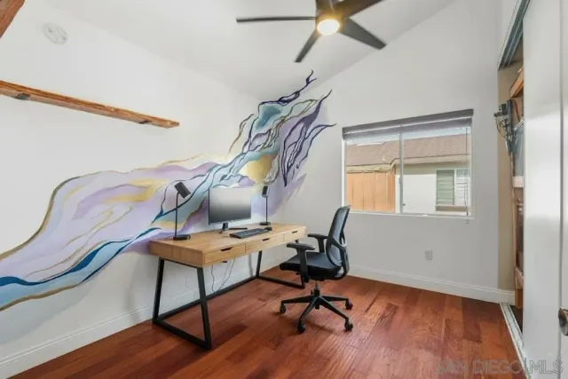 a view of a workspace with furniture and wooden floor