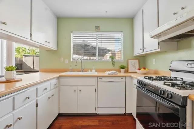 a kitchen with granite countertop a sink stainless steel appliances and cabinets