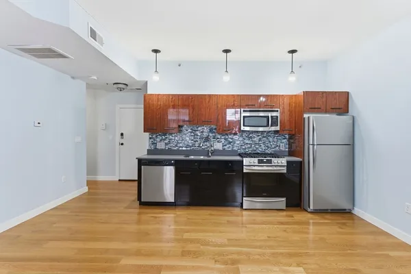 a kitchen with stainless steel appliances granite countertop a stove a sink and a refrigerator