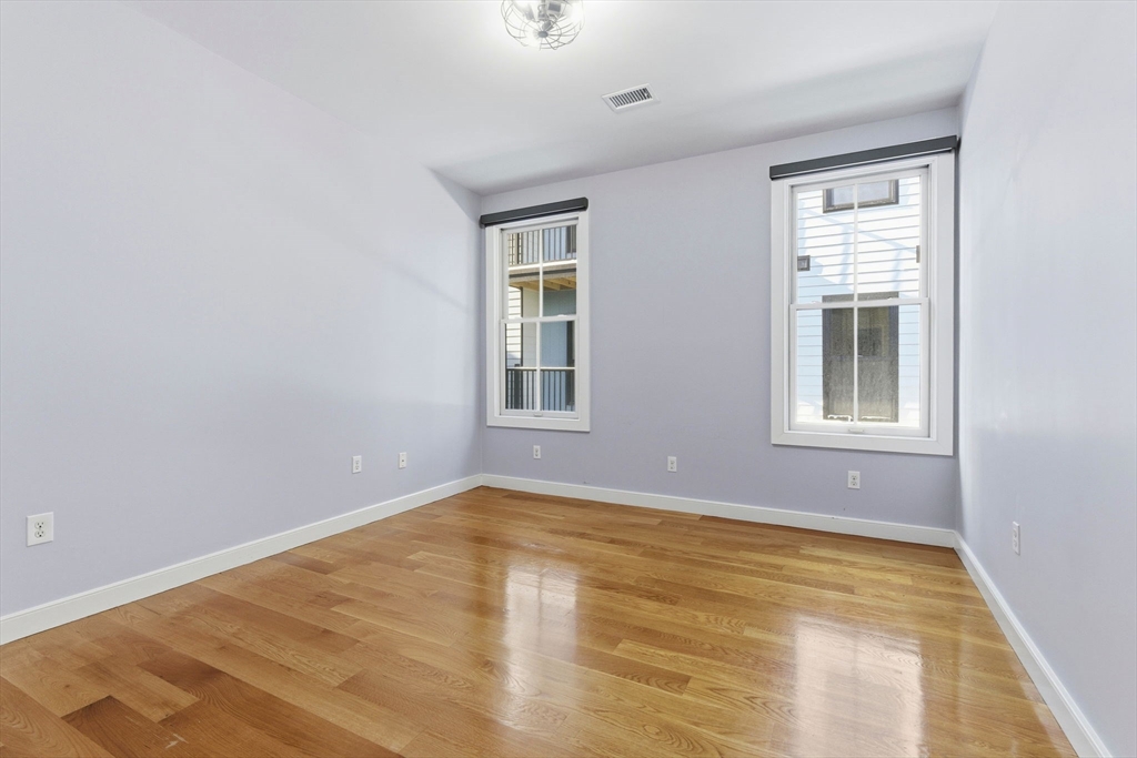 534 Main Street, Unit 11 Melrose, MA 02176 - Photo 3 of 16 a view of an empty room with wooden floor and a window