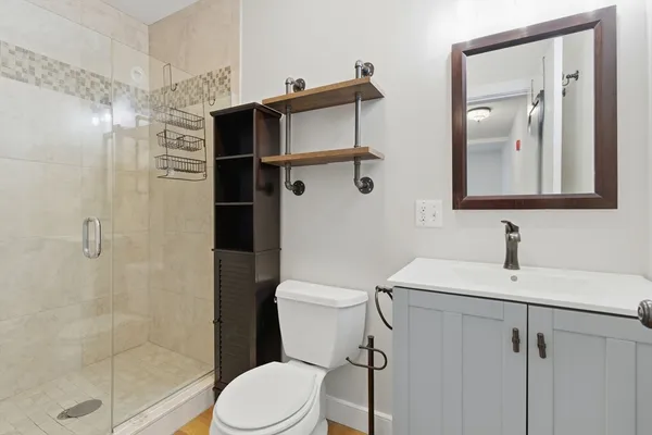 a bathroom with a sink a toilet and shower