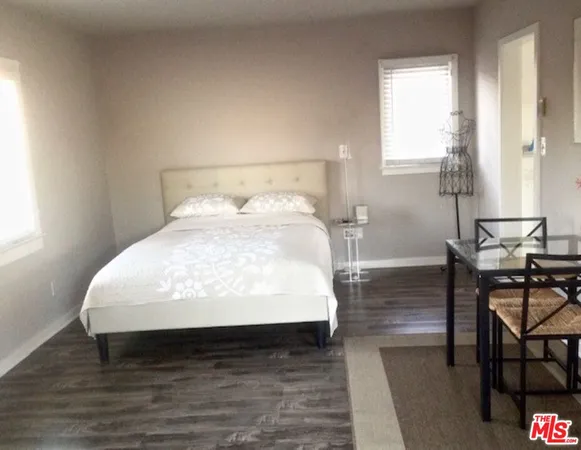 a large bed sitting in a bedroom next to a window