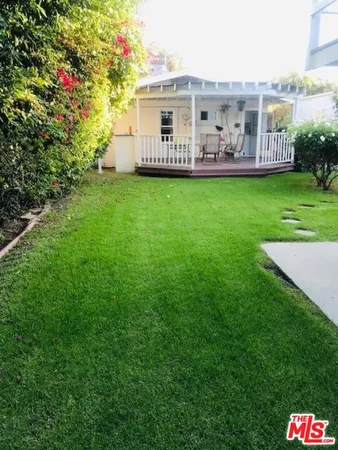 a view of a house with a big yard and large trees
