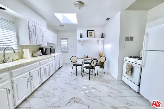 a kitchen with granite countertop a sink cabinets and stainless steel appliances