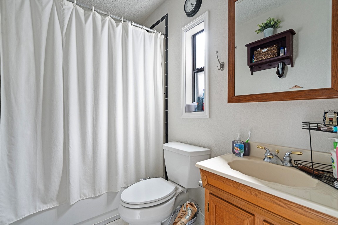2606 Westover Road Austin, TX 78703 - Photo 31 of 38 a bathroom with a sink a toilet and shower curtain