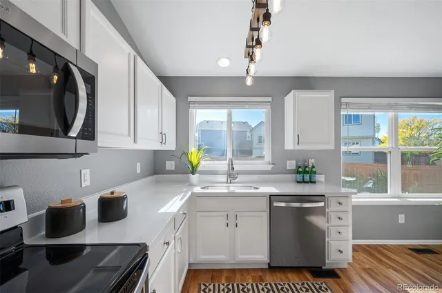 a kitchen with a stove a sink and a cabinets