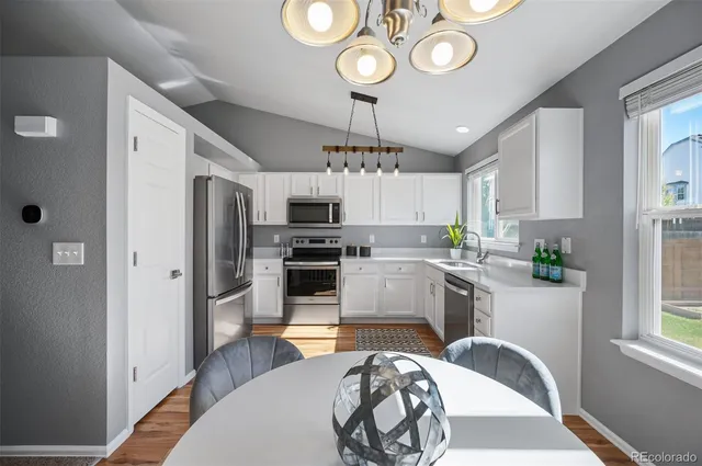 a kitchen with stainless steel appliances granite countertop a sink a stove a refrigerator cabinets and a window