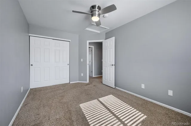 a bedroom with a chandelier fan and a bathroom