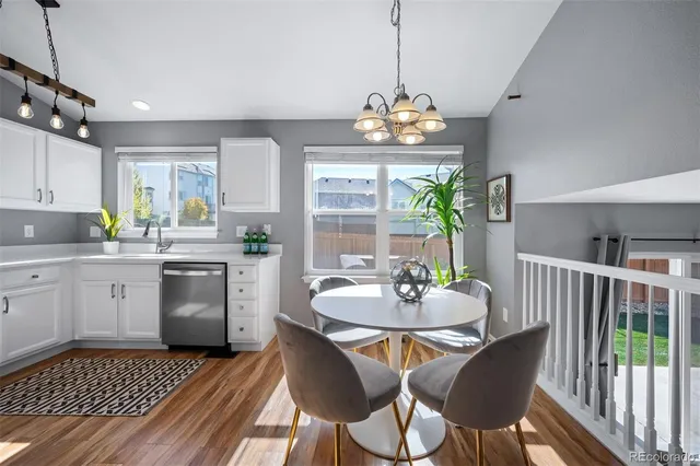 a kitchen with a dining table a sink dishwasher a dining table and chairs with wooden floor