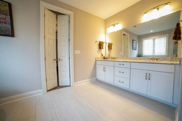 a spacious bathroom with a granite countertop sink mirror and