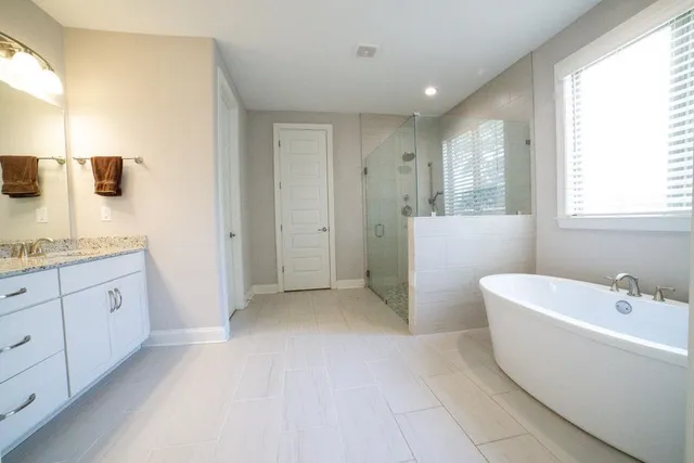 a bathroom with a bathtub sink and mirror