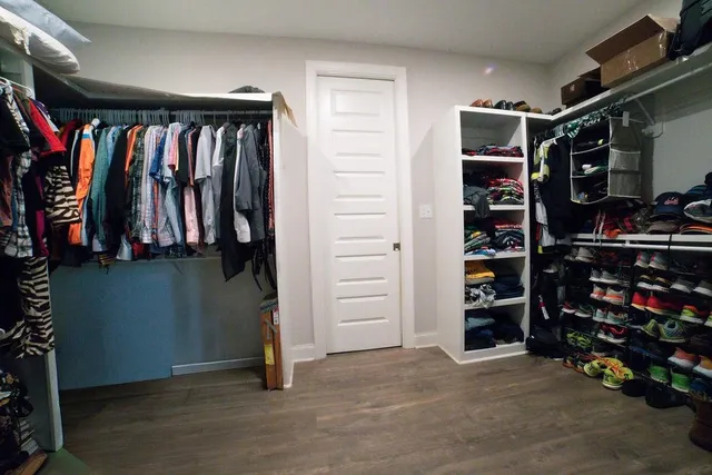 a view of walk in closet with clothes and shoes