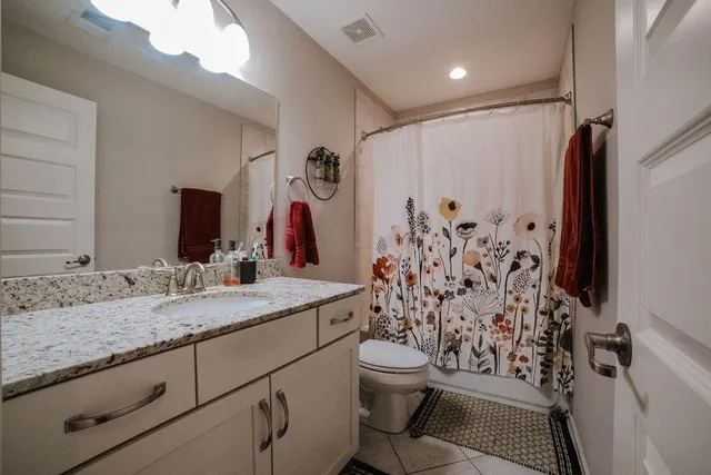 a bathroom with a granite countertop sink toilet and shower