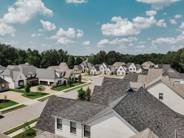 an aerial view of a house with a yard and lake view