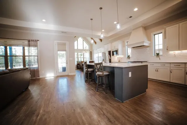 a kitchen with stainless steel appliances granite countertop wooden floors and view living room