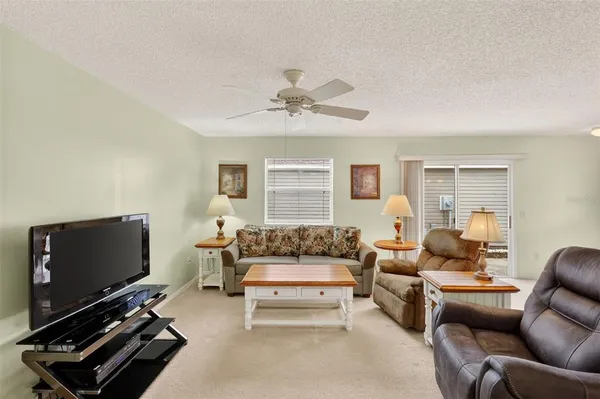 a living room with furniture a flat screen tv and a window