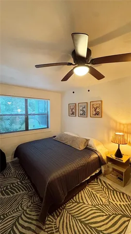 a bedroom with a bed and lamp on desk
