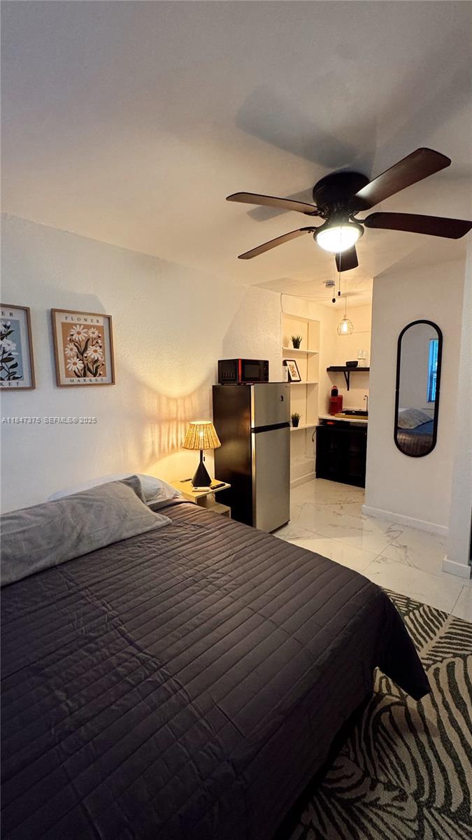 460 Northwest 109th Street, Unit STUDIO Miami, FL 33168 - Photo 2 of 8 a bedroom with a bed and a view of kitchen