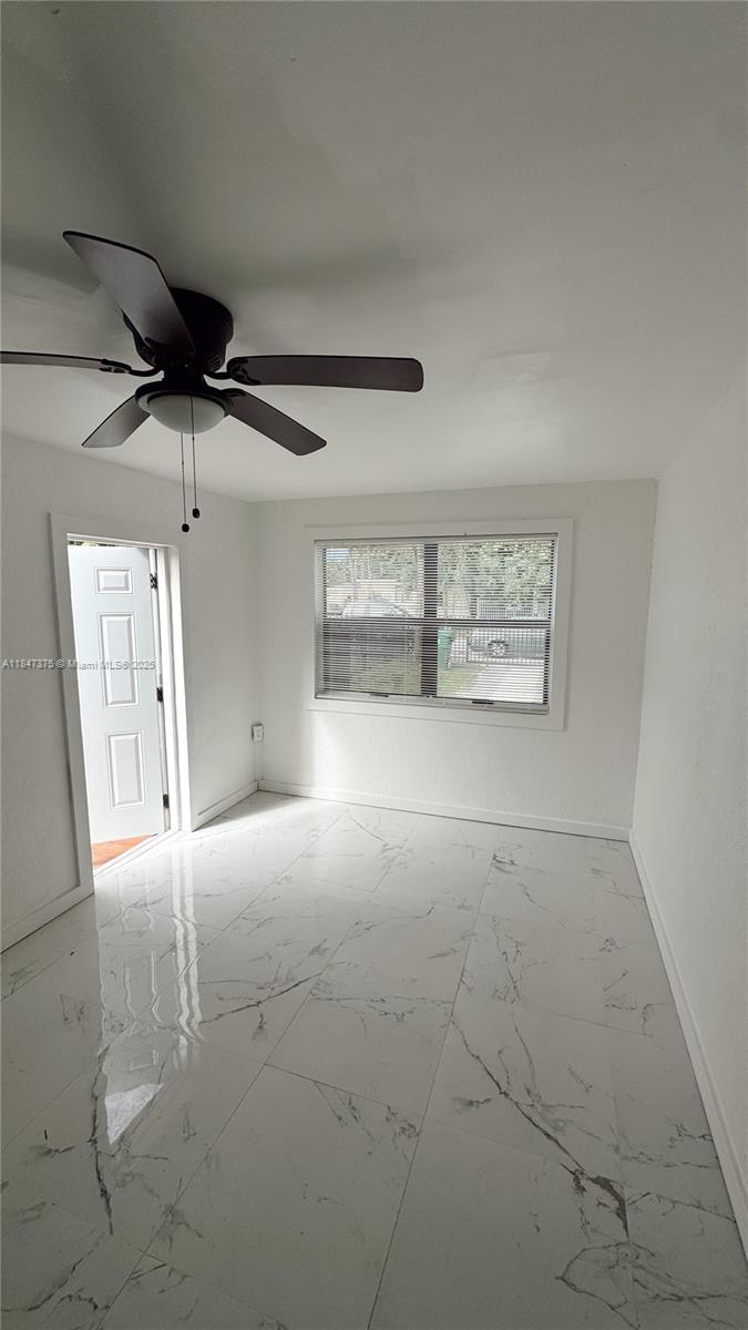 460 Northwest 109th Street, Unit STUDIO Miami, FL 33168 - Photo 6 of 8 a view of a livingroom with a ceiling fan and window