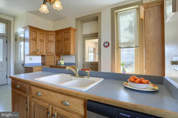 a kitchen with stainless steel appliances granite countertop a stove top oven a sink dishwasher a dining table and chairs with wooden floor